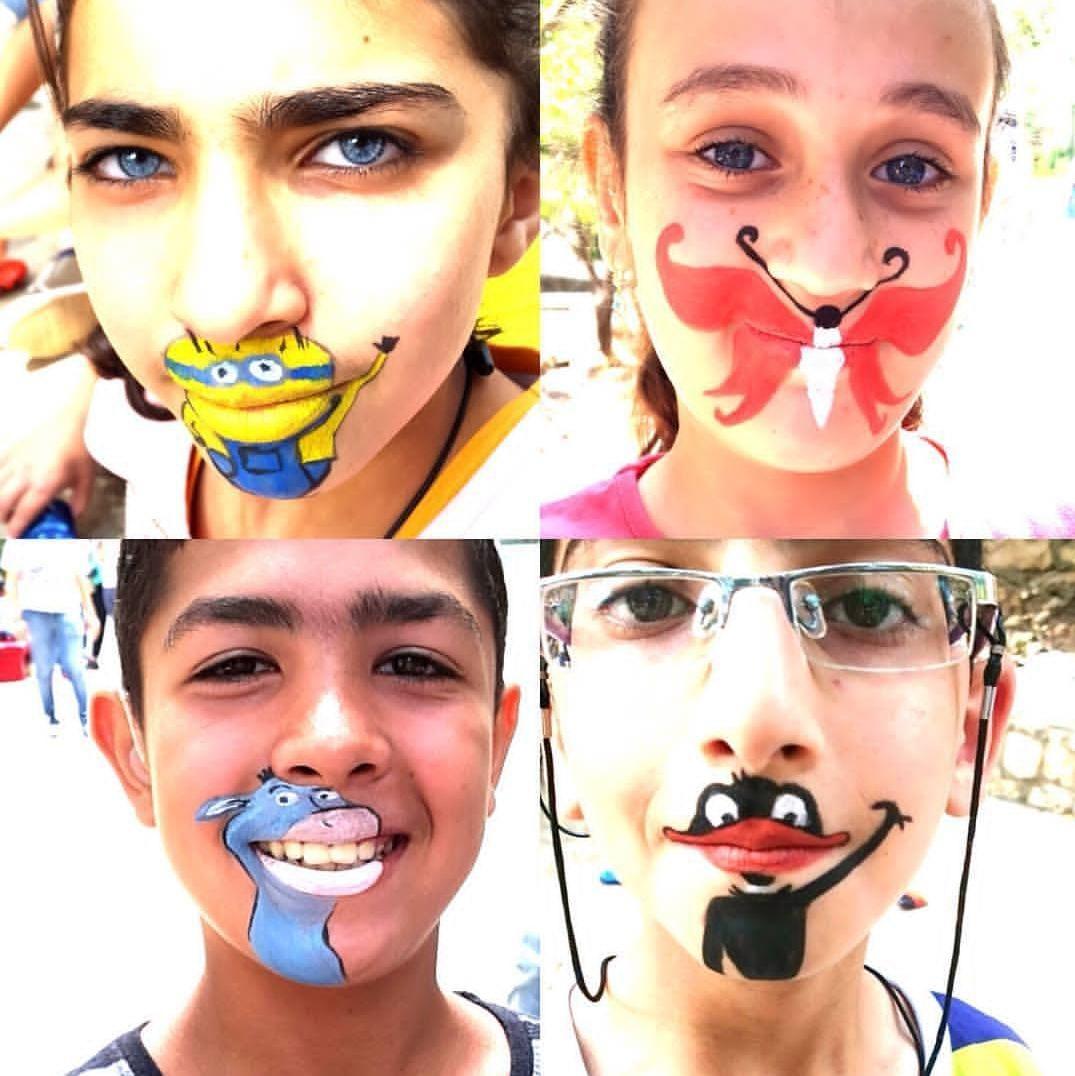 A collage of four children with playful cartoon-character face paintings on their mouths and chins